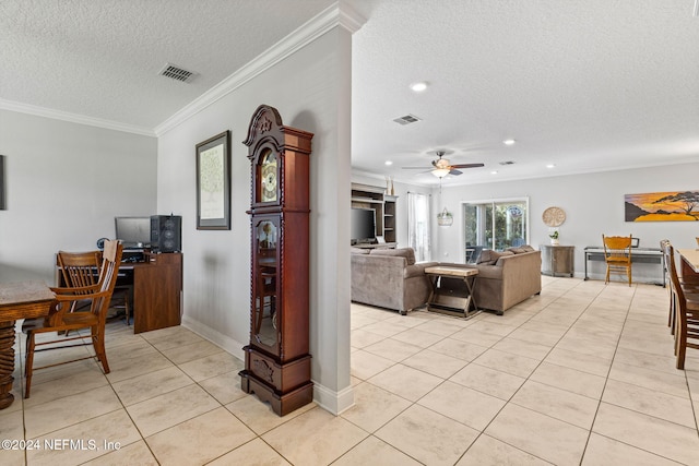 living room with a textured ceiling, ceiling fan, light tile patterned floors, and crown molding