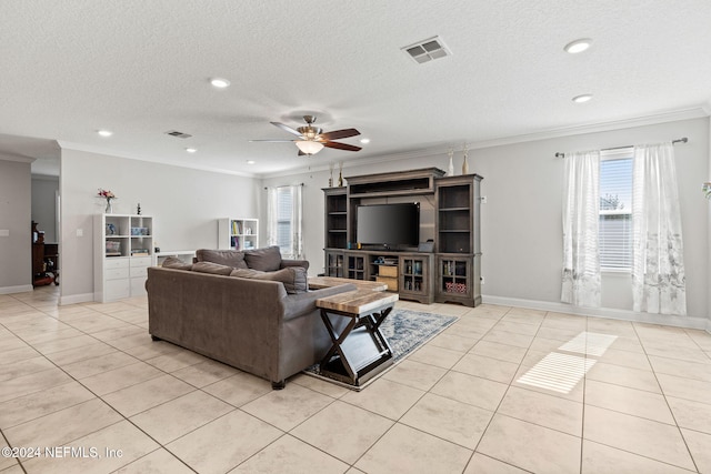 tiled living room featuring plenty of natural light, ceiling fan, ornamental molding, and a textured ceiling