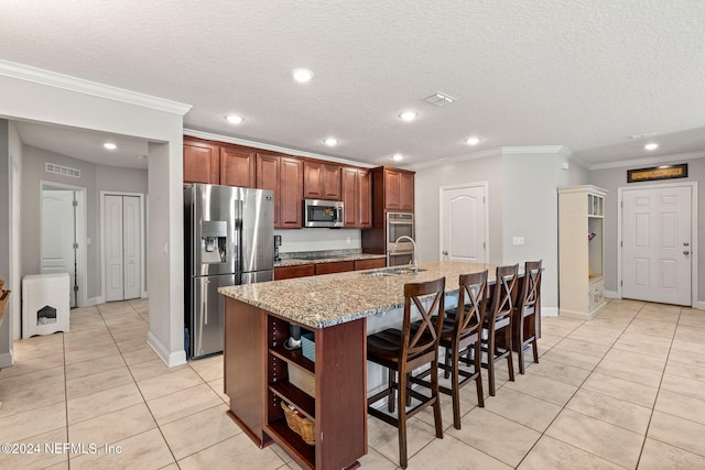 kitchen featuring light stone countertops, sink, a breakfast bar, a center island with sink, and appliances with stainless steel finishes