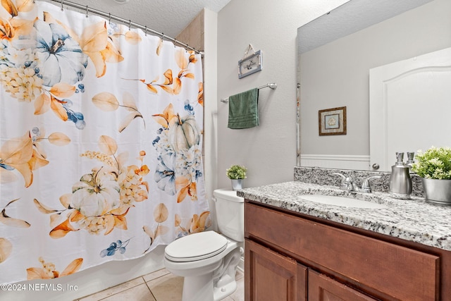 bathroom with vanity, a textured ceiling, tile patterned floors, and toilet