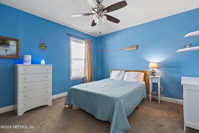 carpeted bedroom featuring ceiling fan and a textured ceiling