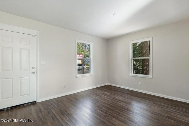 unfurnished room with dark hardwood / wood-style flooring