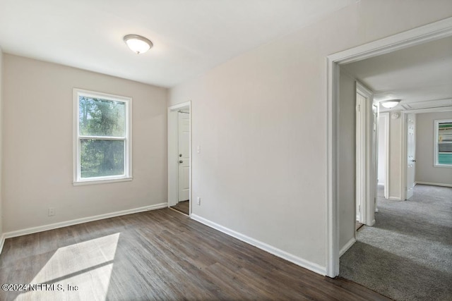 empty room with dark hardwood / wood-style flooring