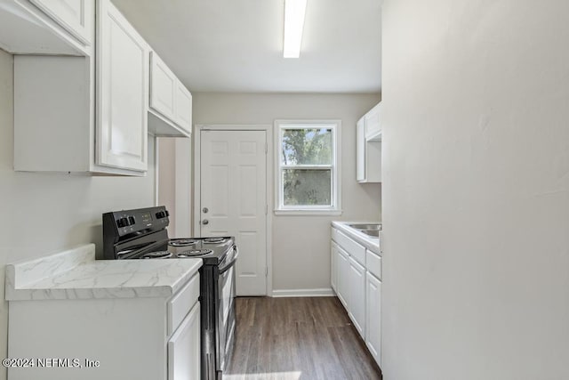 kitchen with white cabinetry, light stone counters, black range with electric cooktop, and hardwood / wood-style floors