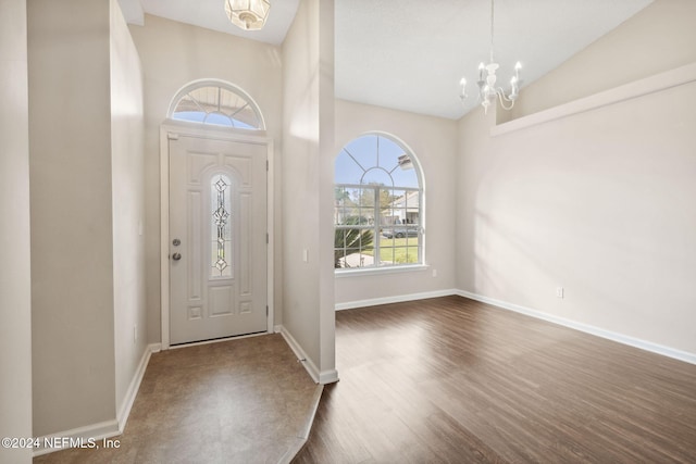 entrance foyer with a notable chandelier, dark hardwood / wood-style flooring, and high vaulted ceiling