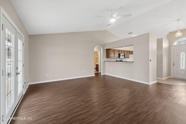 unfurnished living room featuring dark hardwood / wood-style floors, ceiling fan, and lofted ceiling