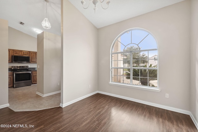 unfurnished dining area featuring a wealth of natural light, dark hardwood / wood-style flooring, lofted ceiling, and a notable chandelier