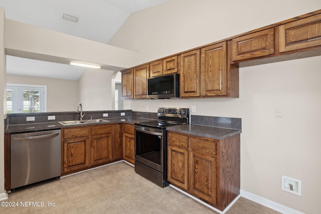 kitchen featuring french doors, sink, appliances with stainless steel finishes, and vaulted ceiling