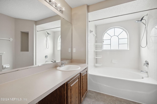 bathroom featuring a textured ceiling, vanity, and  shower combination