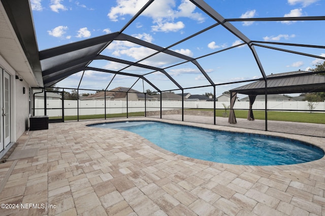 view of pool featuring central air condition unit, glass enclosure, and a patio area