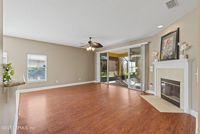 unfurnished living room featuring a fireplace, a textured ceiling, and a healthy amount of sunlight