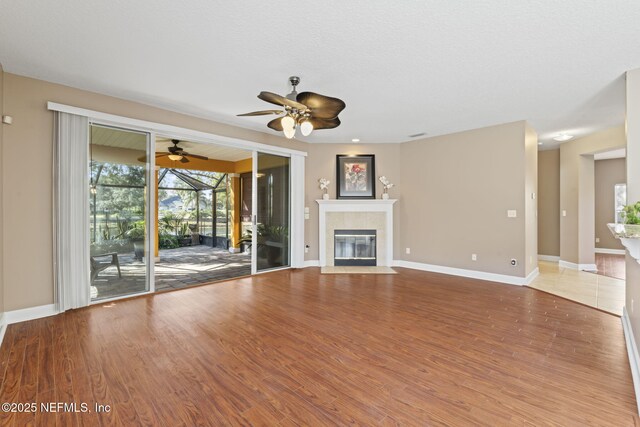 unfurnished living room featuring ceiling fan, a fireplace, and hardwood / wood-style floors