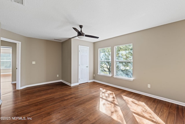 unfurnished bedroom with ceiling fan, a closet, dark wood-type flooring, and a textured ceiling