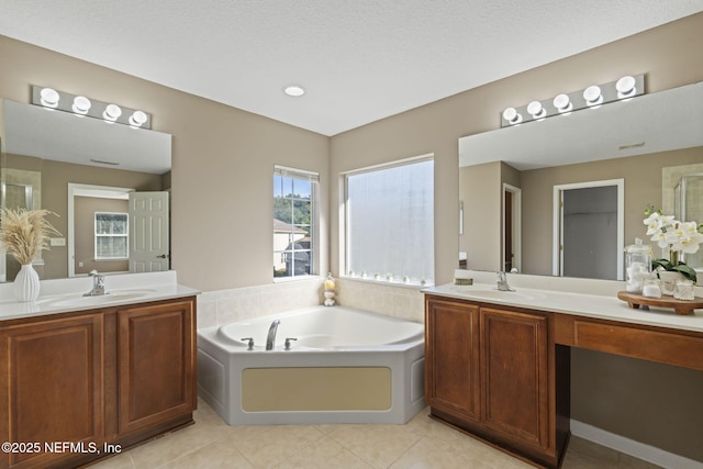 bathroom featuring a bath, tile patterned flooring, a textured ceiling, and vanity