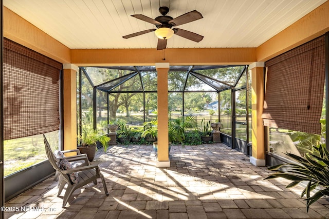 unfurnished sunroom with ceiling fan