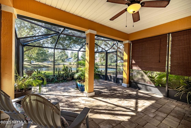 view of patio featuring ceiling fan and glass enclosure