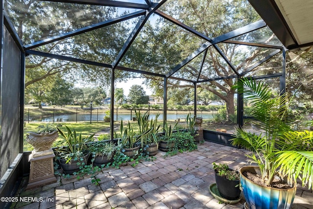 view of patio with a water view and a lanai