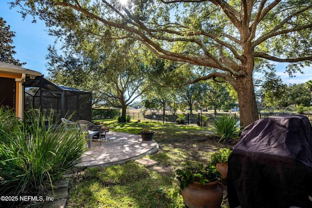 view of yard with a patio area and glass enclosure