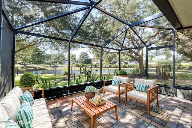 view of patio featuring an outdoor living space, a water view, and glass enclosure