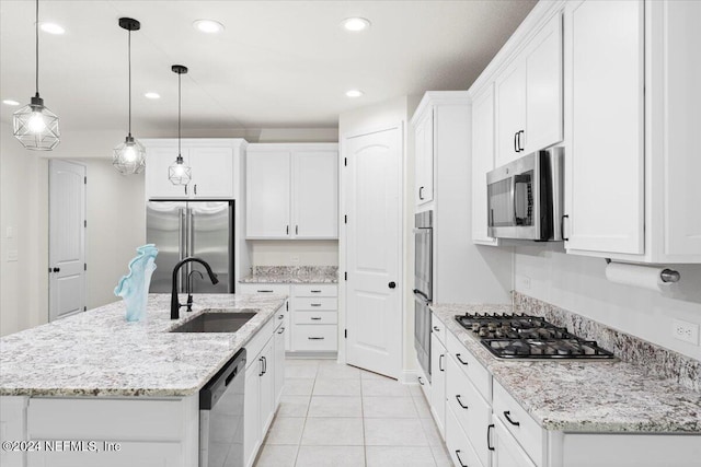 kitchen featuring white cabinets, stainless steel appliances, and a center island with sink