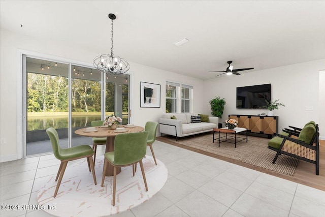 dining space featuring ceiling fan with notable chandelier and light tile patterned floors