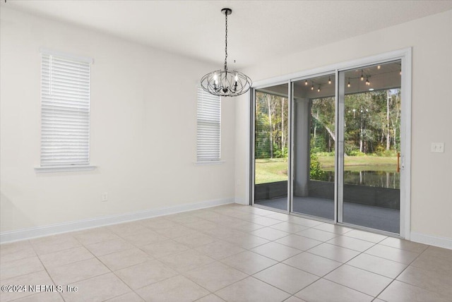 unfurnished room with light tile patterned flooring and an inviting chandelier