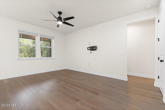 spare room with ceiling fan and dark wood-type flooring