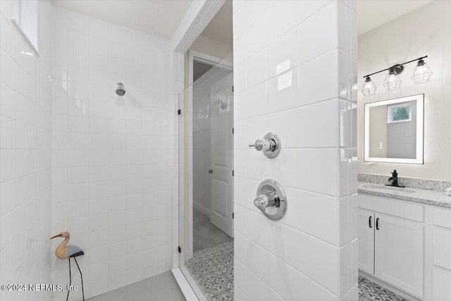 bathroom with vanity and a tile shower