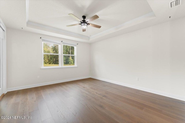 spare room featuring hardwood / wood-style floors, a tray ceiling, ceiling fan, and ornamental molding