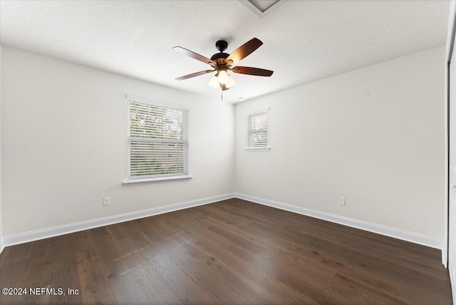 empty room featuring a textured ceiling, dark hardwood / wood-style floors, and ceiling fan