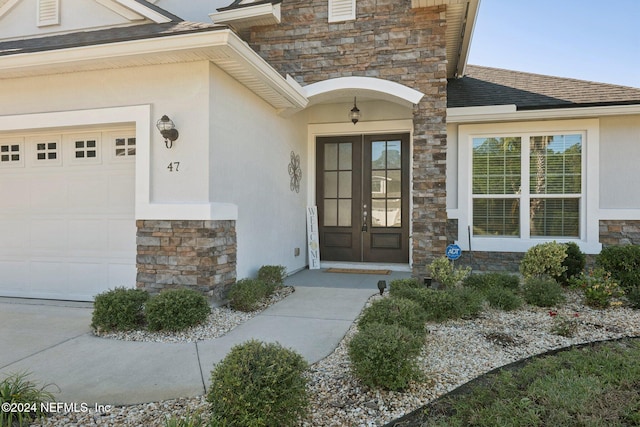 entrance to property with a garage and french doors