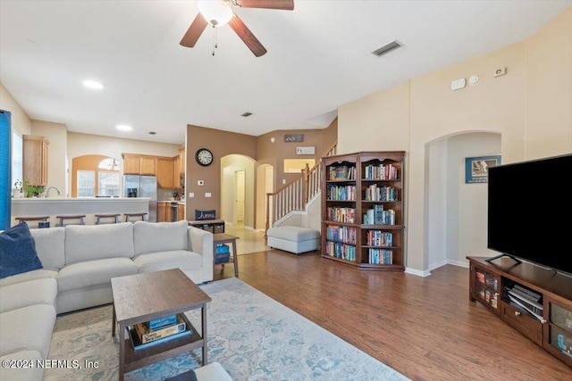 living room with ceiling fan and dark hardwood / wood-style flooring