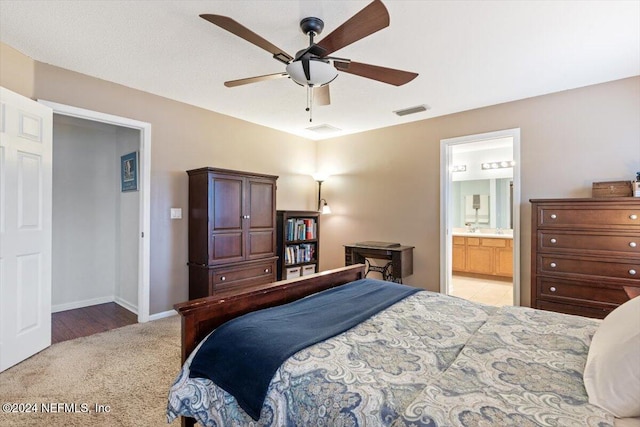 bedroom featuring connected bathroom, ceiling fan, and light carpet