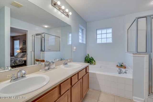 bathroom with tile patterned floors, vanity, and shower with separate bathtub