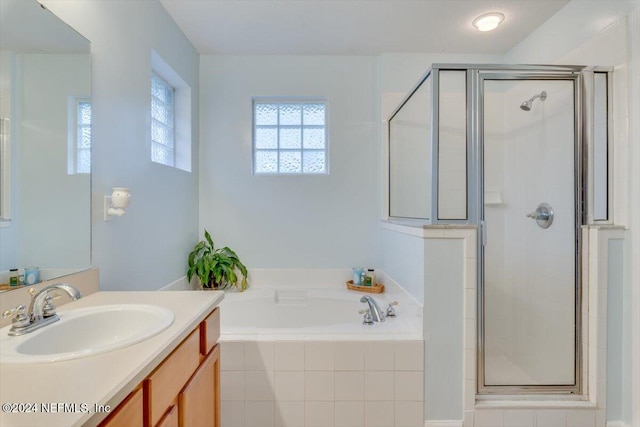 bathroom featuring plus walk in shower and vanity