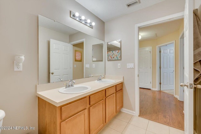 bathroom featuring wood-type flooring, vanity, and a textured ceiling