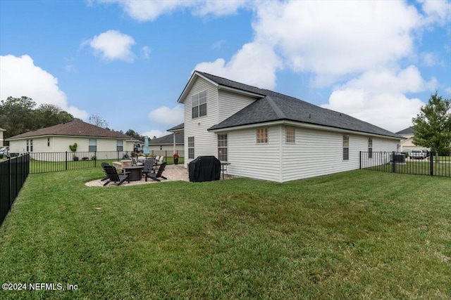 rear view of house featuring a yard and a patio