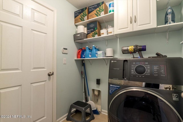 laundry room featuring cabinets and washer / dryer