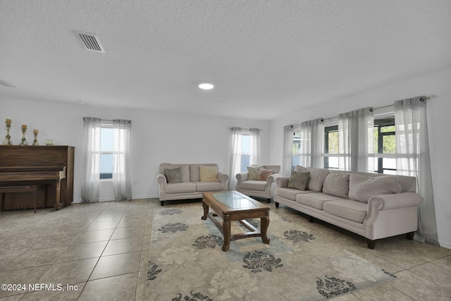 tiled living room featuring plenty of natural light and a textured ceiling