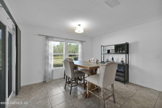 dining space featuring tile patterned flooring and a textured ceiling