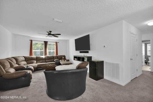 carpeted living room with a textured ceiling and ceiling fan