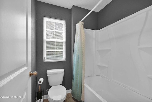 bathroom with toilet and shower / bath combo with shower curtain