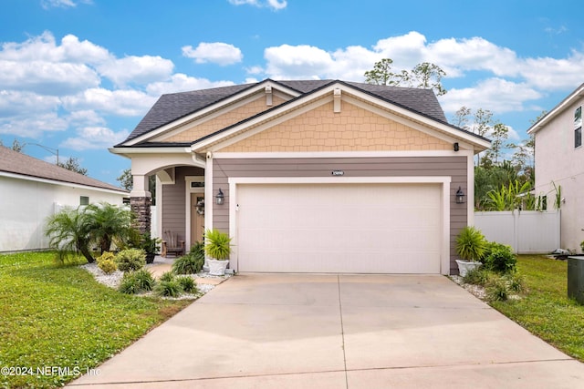 craftsman inspired home with a garage and a front yard