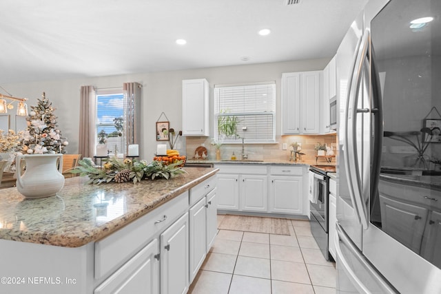 kitchen featuring tasteful backsplash, white cabinetry, sink, and appliances with stainless steel finishes