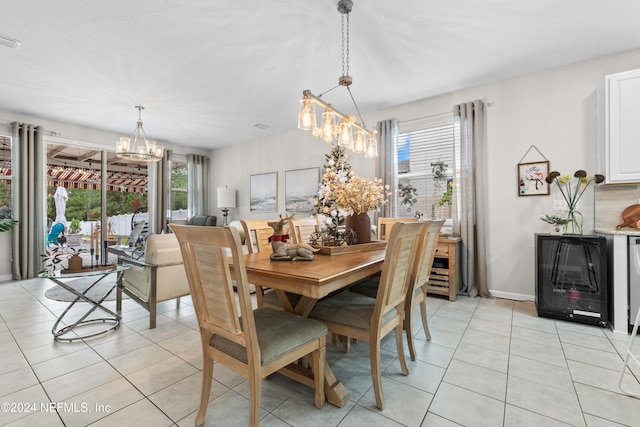 tiled dining area featuring beverage cooler and a chandelier