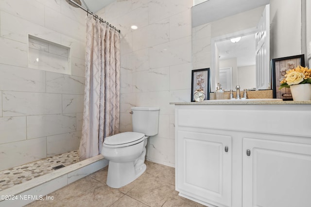 bathroom with toilet, a shower with curtain, vanity, and tile patterned floors