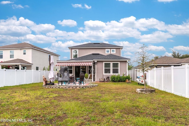 back of house with a lawn and a patio area