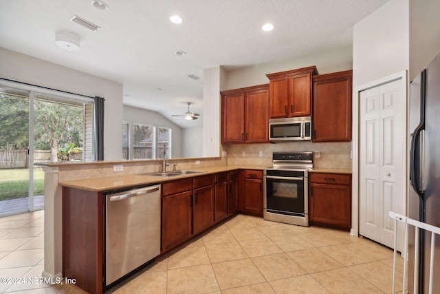 kitchen with kitchen peninsula, appliances with stainless steel finishes, ceiling fan, sink, and light tile patterned flooring