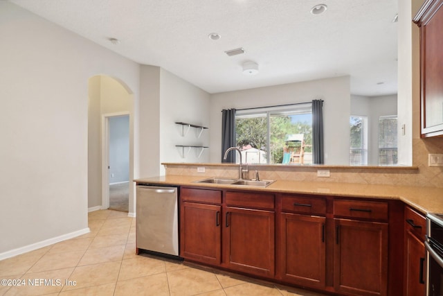 kitchen with decorative backsplash, stainless steel dishwasher, a textured ceiling, sink, and light tile patterned floors