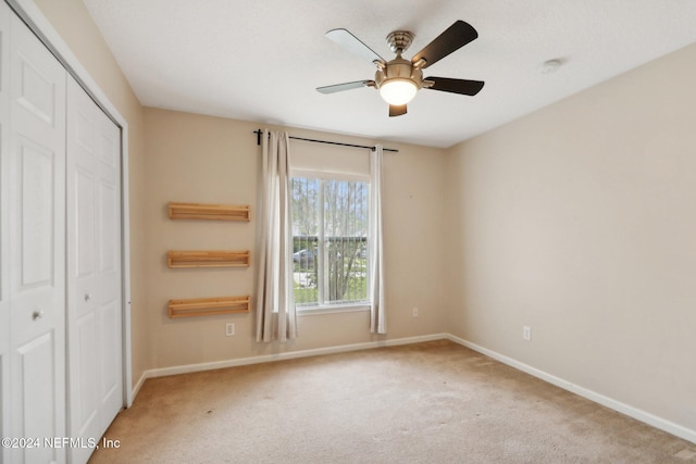 unfurnished bedroom with carpet flooring, a closet, and ceiling fan